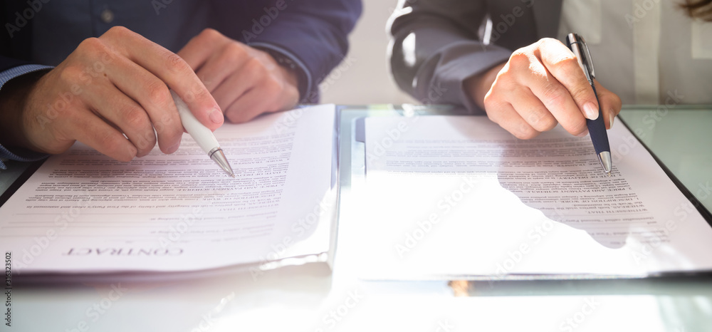 Two Businesspeople Working On Contract Paper Two Businesspeople Working On Contract Paper