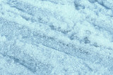 Wet spring snow texture close up. Natural abstract background blue color toned