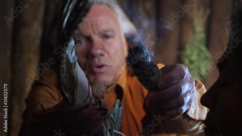 Native American Elder Burns Sage to Bless Cleanse Man for Ritual Ceremony in Hogan