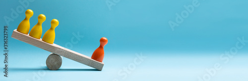 Foto Red And Yellow Pawns Figures Balancing On Wooden Seesaw