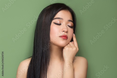 portrait of a woman on a green background. Skin care concept.