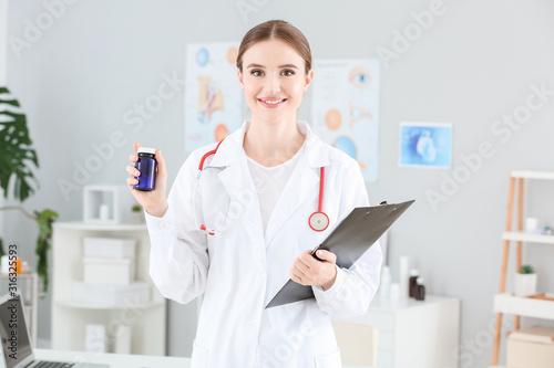 Portrait of female doctor with pills in clinic