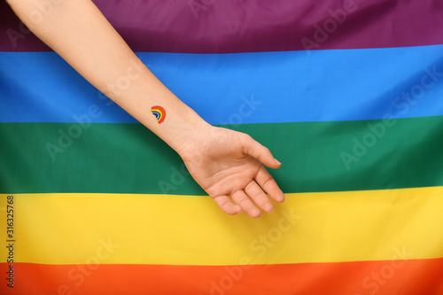 Female hand against rainbow flag. LGBT concept