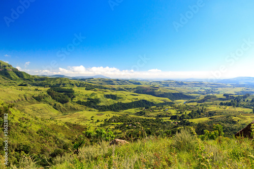 Panoramic view over a green and vast valley on a sunny day, Drakensberg, Giants Castle Game Reserve, South Africa