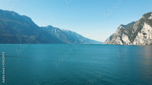 beautiful landscape of blue lake between mountains from birds eye in summer sunny day, rippled water surface