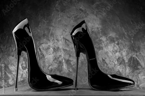 Black fetish shiny patent leather stiletto high heels with ankle strap photo
