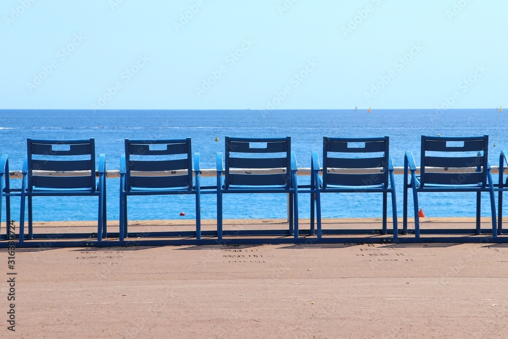 Promenade in Nice. Blue meatal chairs