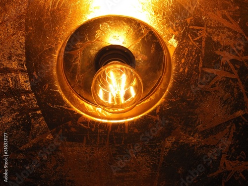 Incandescent light bulb in a copper lamp