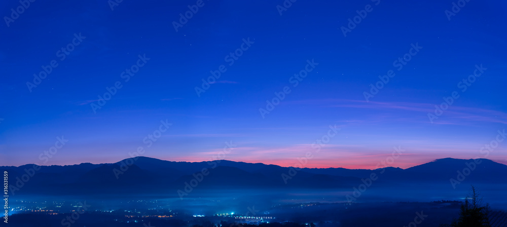 The beauty of the sky before the sun rises over the top of the mountain and a sea of fog below.