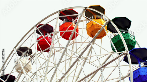 Part of the ferris wheel with open colored cabins on top of the ride