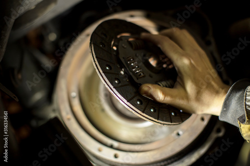 Car engine maintenance. Engine clutch repair. Hands with a mechanic with a clutch disc.