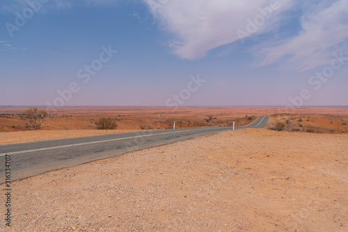 Mundi Mundi Lookout long road view with red dirt and blue sky  it   s a perfect spot to take in one of Australia   s most famous sunset Located about five kilometres North West of Silverton.