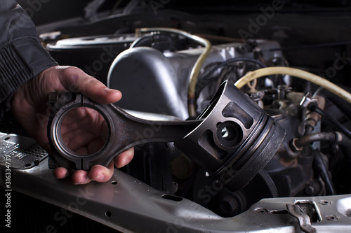 Car engine maintenance. Engine piston system repair. Hands with a mechanic with a piston and connecting rod. © Светлана Лазаренко