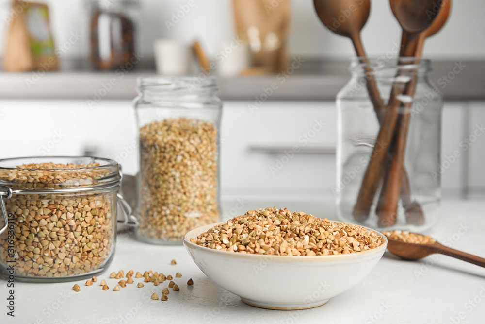 Uncooked green buckwheat grains on white table Uncooked green buckwheat grains on white table