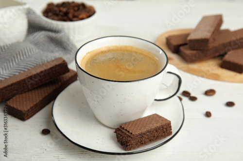 Fototapeta Naklejka Na Ścianę i Meble -  Delicious wafers and cup of coffee for breakfast on white wooden table