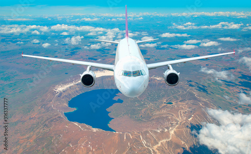 Passenger airplane flying over Nemrut crater lake