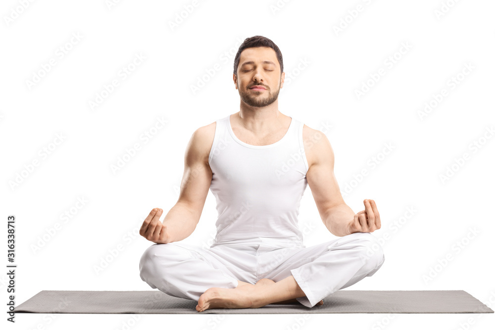 Young man meditating on a yoga mat Stock Photo