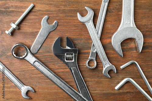 Auto mechanic's tools on wooden background, flat lay