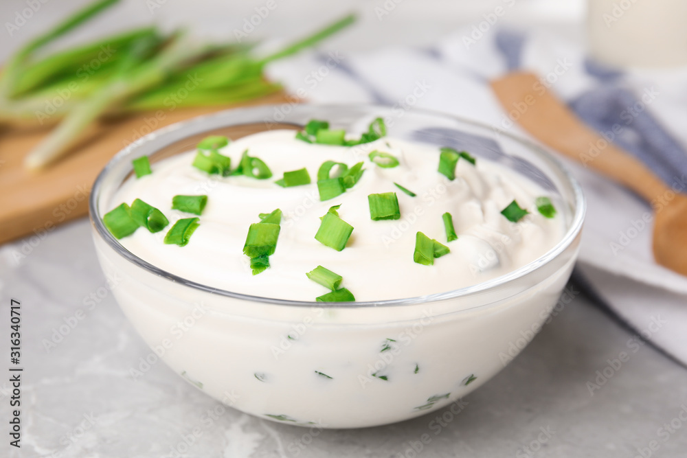 Fresh sour cream with onion on grey marble table, closeup Fresh sour cream with onion on grey marble table, closeup