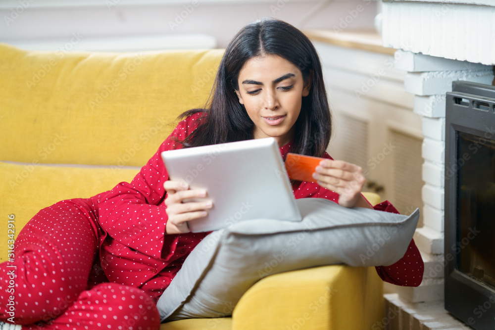 Persian woman at home using digital tablet Persian woman at home using digital tablet