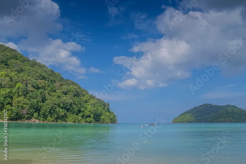 view of two mountain around with blue-green sea and cloudy sky background, Khao Chong Kad Bay, Surin island, Mu Ko Surin National Park, Phang Nga, southern of Thailand.