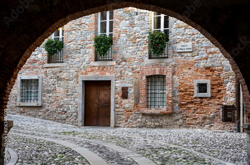 Medieval street arch under an ancient brick wall of a building facade in the town of Cividale del Friuli. Udine  Friuli Venezia Giulia  Italy
