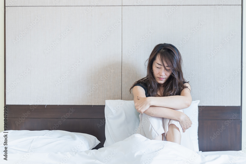 depress woman sitting on bed in room with lower head, sadness and depress concept depress woman sitting on bed in room with lower head, sadness and depress concept