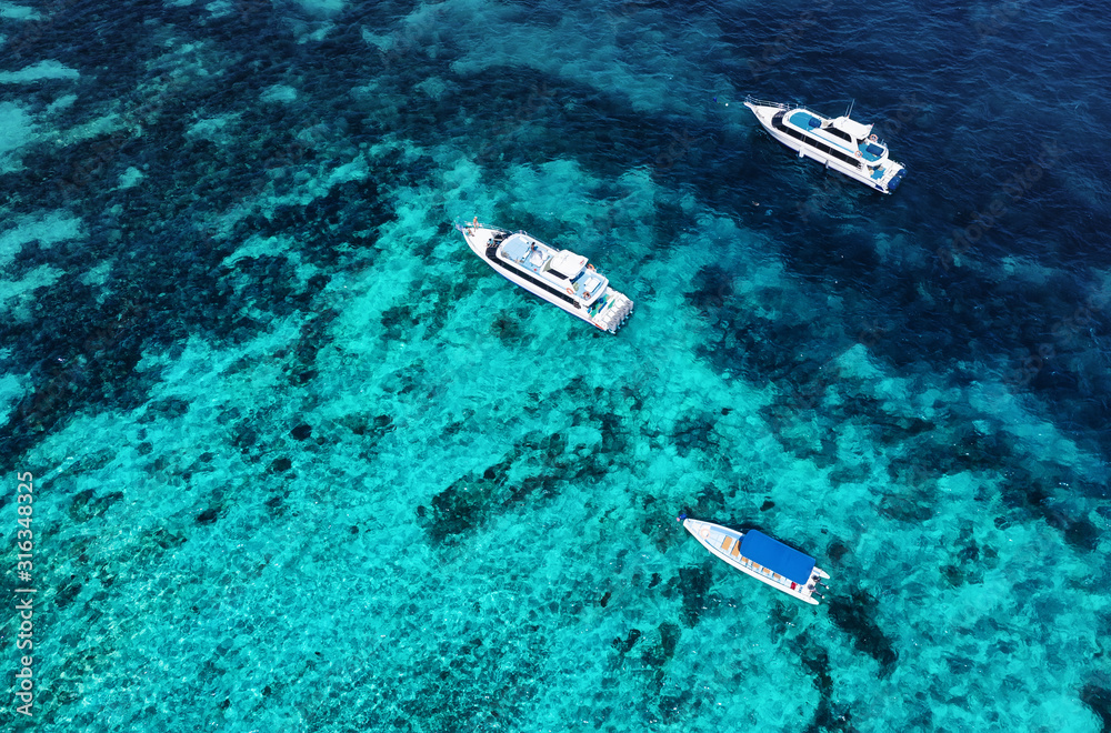 Fototapeta premium Boats on the water surface from top view. Azure water background from drone. Summer seascape from air. Travel - image