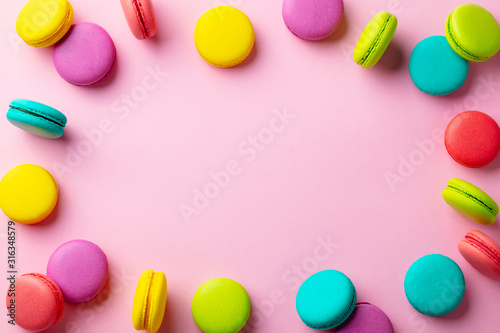 Macaroons dessert on pink pastel background. Copy space. Top view.