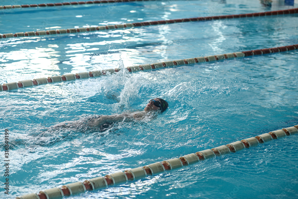 A teenager is swimming in a sports pool