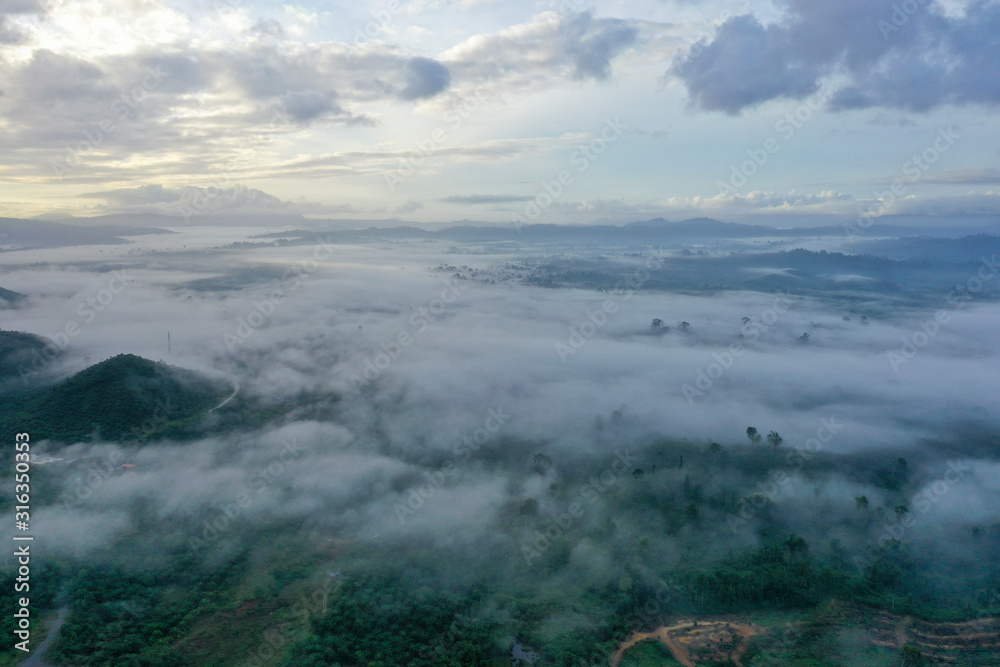 Aerial view misty and foggy morning at the Imbak Village in Tongod, Sabah, Malaysia, Borneo. Certain part with rainforest jungle and palm oil plantation.