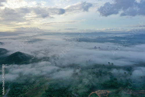 Aerial view misty and foggy morning at the Imbak Village in Tongod, Sabah, Malaysia, Borneo. Certain part with rainforest jungle and palm oil plantation.