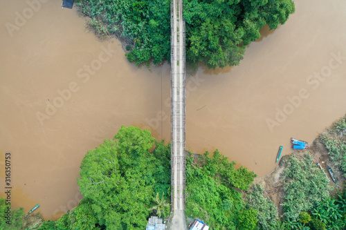 Aerial view of the wild river with the old wooden bridge connecting between two mainland in Kampung Imbak, Tongod, Sabah, Malaysia, Borneo. photo