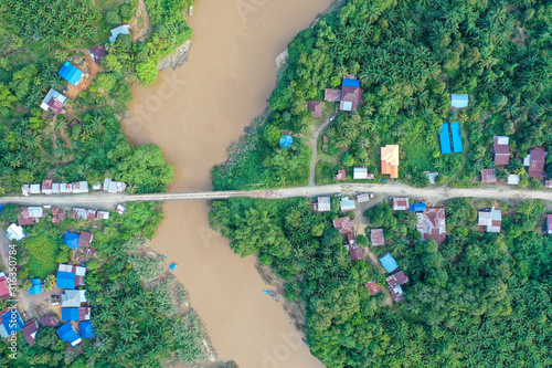 Aerial view of the wild river with the old wooden bridge connecting between two mainland in Kampung Imbak, Tongod, Sabah, Malaysia, Borneo. photo