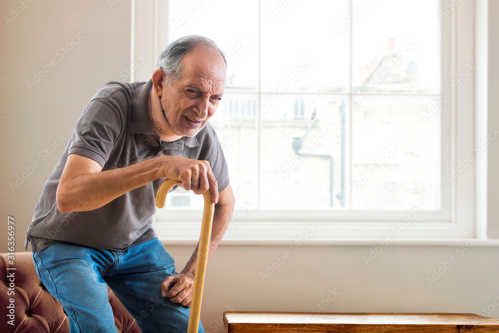Senior man having a knee pain trying to stand up at home. (Health and fitness) Senior man having a knee pain trying to stand up at home. (Health and fitness)