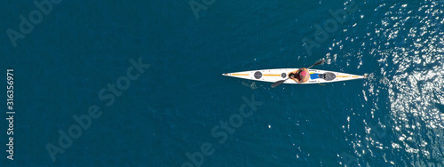 Aerial drone ultra wide photo of fit athletes practising sport kayak in tropical exotic lake with emerald water © aerial-drone