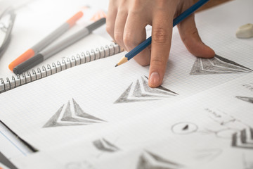 Graphic designer drawing sketches logo design.