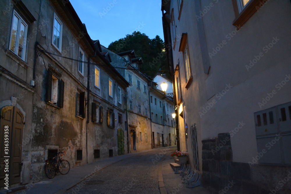 Straße mit alten Gebäuden und Fahrrad bei Abenddämmerung