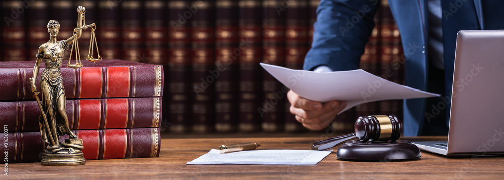 Φωτογραφία Lawyer Holding Documents Near Mallet And Laptop