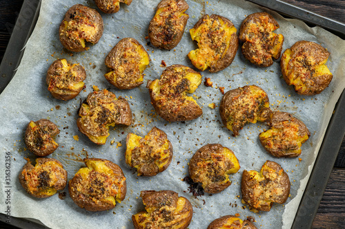 Crispy smashed potatoes roasted with garlic and parmesan.  photo