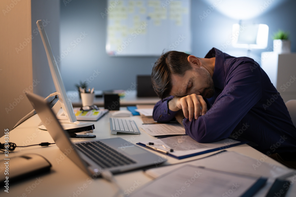 Tired Businessman Sleeping While Calculating Expenses In Office Tired Businessman Sleeping While Calculating Expenses In Office