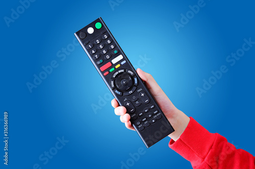 Asian teenage girl hand holding a digital TV remote control