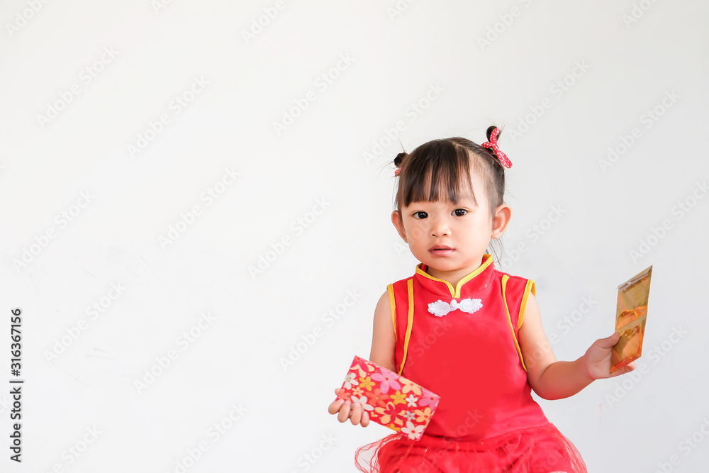 Chinese New Year festival concept, Portrait image of 1-2 yeas old baby. Happy Asian Chinese 's baby girl in the red clothes. She holding a pocket money gift in her hand. On white background. Chinese New Year festival concept, Portrait image of 1-2 yeas old baby. Happy Asian Chinese 's baby girl in the red clothes. She holding a pocket money gift in her hand. On white background.