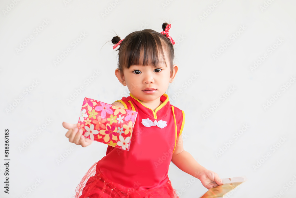 Chinese New Year festival concept, Portrait image of 1-2 yeas old baby. Happy Asian Chinese 's baby girl in the red clothes. She holding a pocket money gift in her hand. On white background. Chinese New Year festival concept, Portrait image of 1-2 yeas old baby. Happy Asian Chinese 's baby girl in the red clothes. She holding a pocket money gift in her hand. On white background.