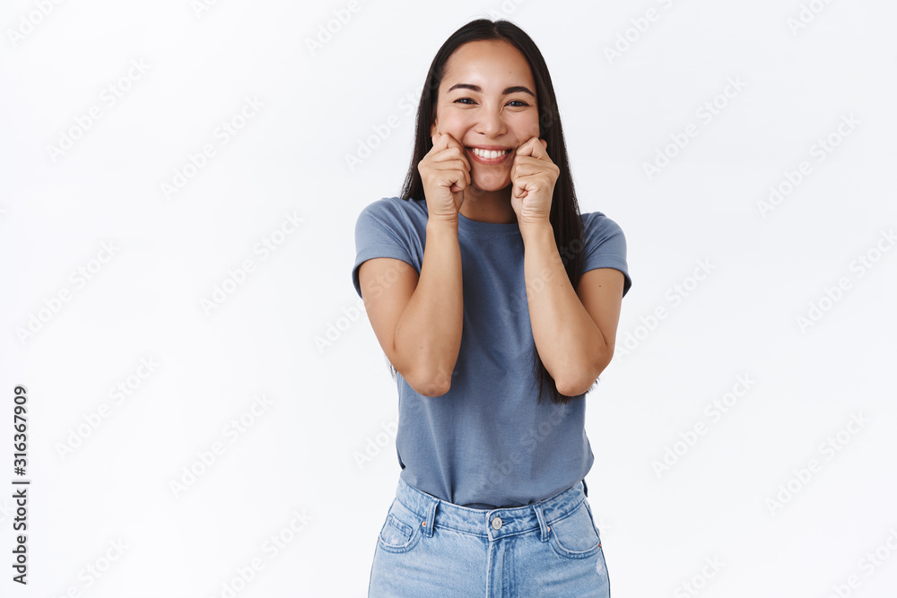Happy, silly and cute tender asian brunette woman in t-shirt, squeez her cheeks and pulling beaming cheerful smile, squinting, mimicking funny faces, standing white background joyful Happy, silly and cute tender asian brunette woman in t-shirt, squeez her cheeks and pulling beaming cheerful smile, squinting, mimicking funny faces, standing white background joyful