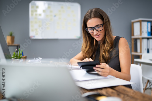 Smiling Businesswoman Calculating Tax