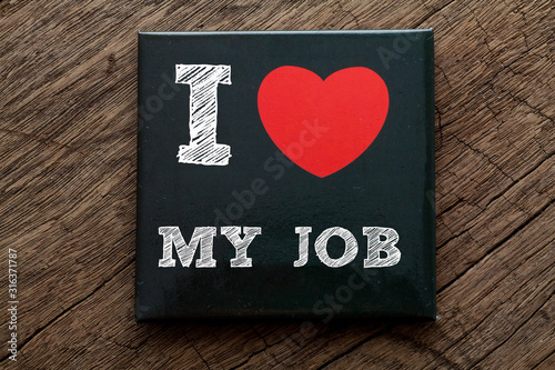I Love My Job written on black note with wood background