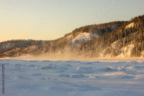 snow-covered hills  evergreen trees on the slopes  in the sunset. Lots of snow and frost trees. 