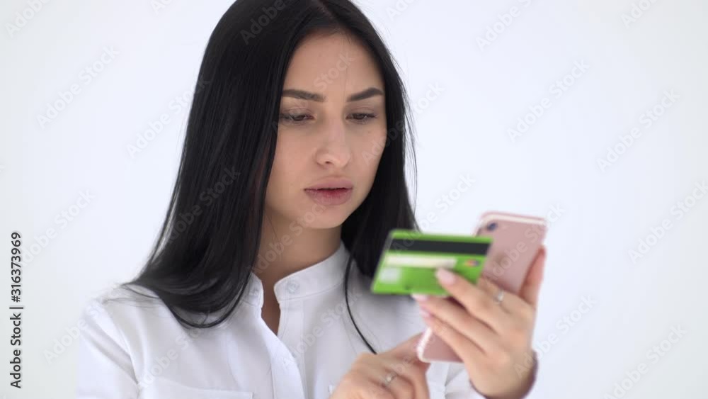 The girl dials in the phone data plastic card. Shopaholic pays for the purchase via the Internet The girl dials in the phone data plastic card. Shopaholic pays for the purchase via the Internet
