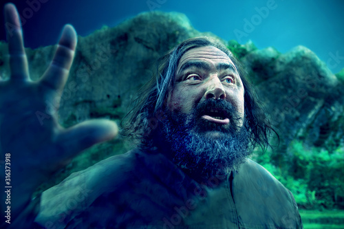 Φωτογραφία bearded old man at night on a background of mountains with a raised hand